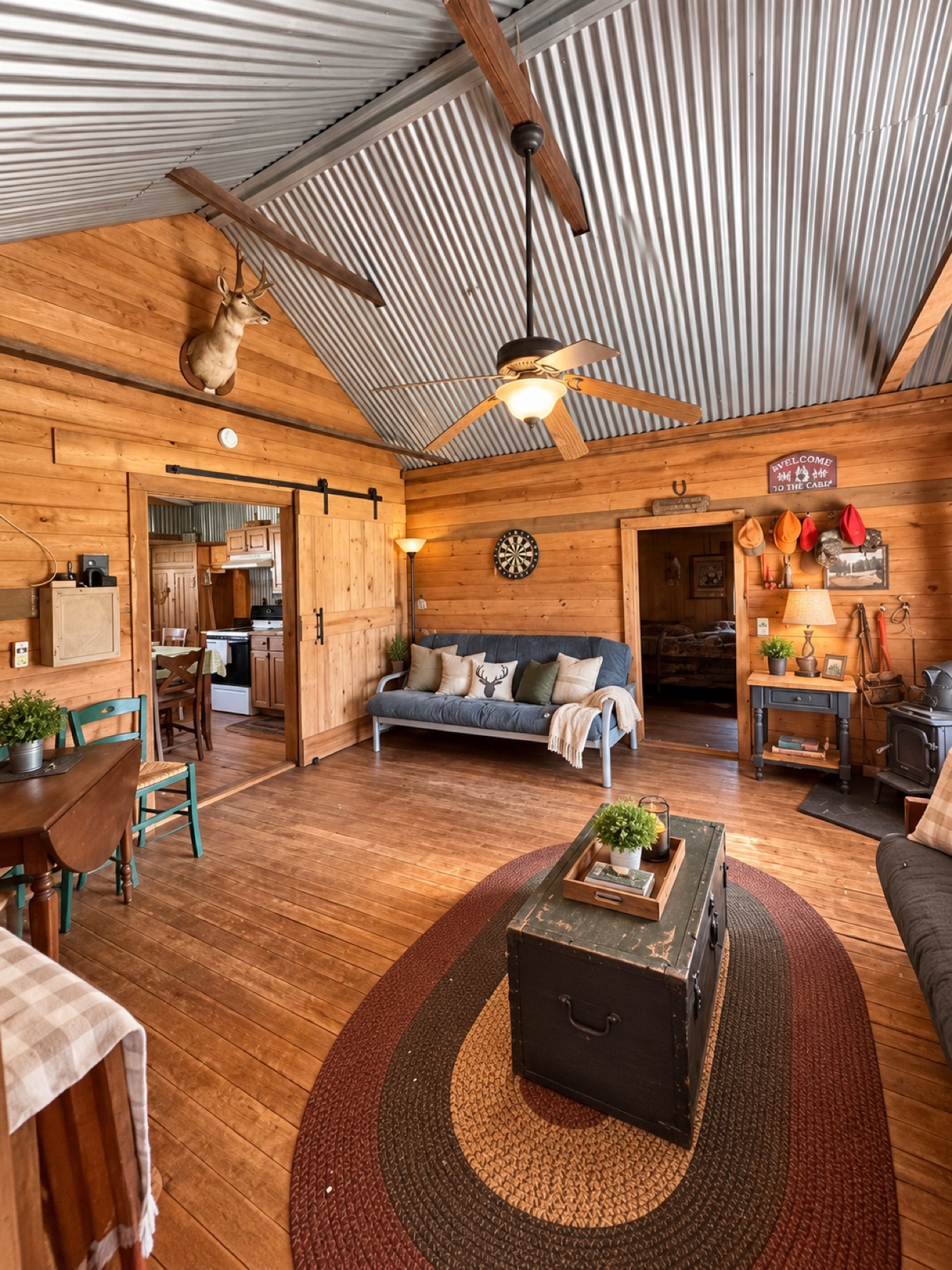 Cabin living room with vaulted metal ceiling and kitchen access
